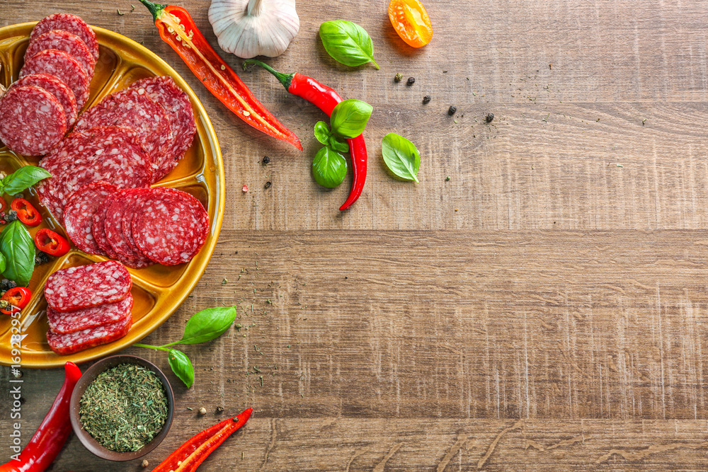 Poster Plate with sliced different sausages and chili pepper on table