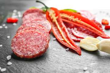 Delicious sliced sausage, chili pepper, garlic and salt, closeup