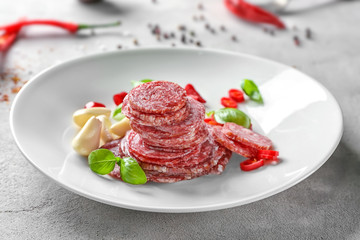 Delicious sliced sausage with garlic and chili pepper on plate