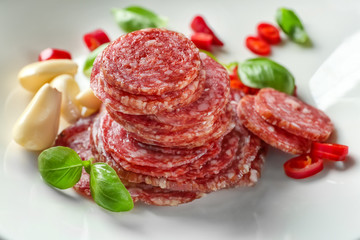 Delicious sliced sausage with garlic and chili pepper on plate
