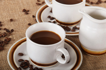 cups of coffee and milk and roasted coffee beans
