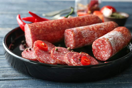 Plate with delicious sliced sausage and chili pepper, closeup