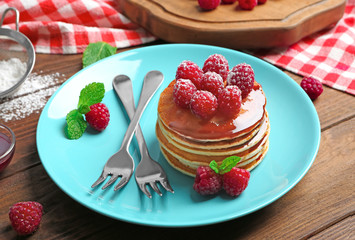 Plate with delicious pancakes on table