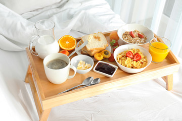 Delicious sweet breakfast with coffee on bed