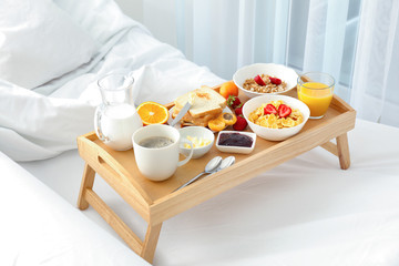 Delicious sweet breakfast with coffee on bed