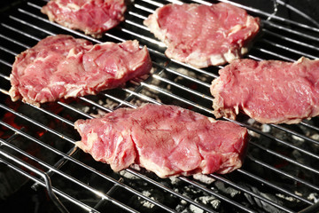 Raw steaks on grill outdoors