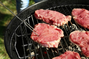 Raw steaks on grill outdoors