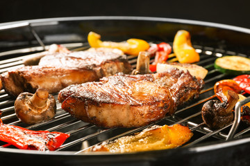 Tasty steaks and vegetables on barbecue grill