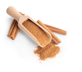 Scoop with sweet cinnamon sugar on white background