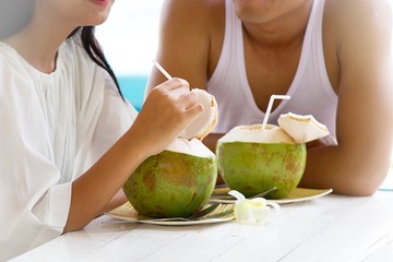 Couple is having coconut drinks at seaside