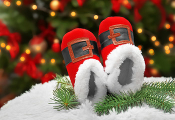 Christmas baby booties on blurred background