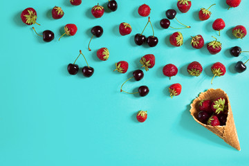 Strawberry and cherries in a waffle horn on a blue background