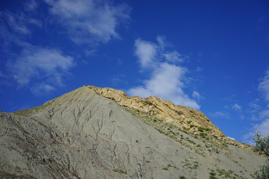 the hill of volcanic origin on the background of blue sky with white clouds in the Crimea