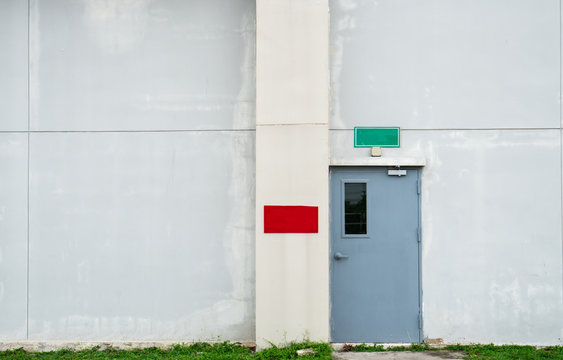 Closed Grey Door With Green And Red Text Box On White Concrete Wall With Copy Space