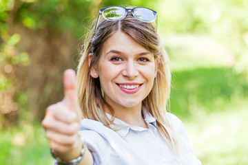 Woman showing thumbs up in the park