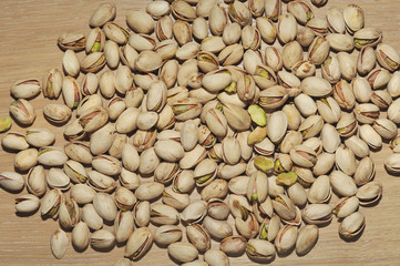 Pistachios on wooden background. Many pistachios. Pistachios background. Pistachios for backgrounds or textures. Pistachio nuts