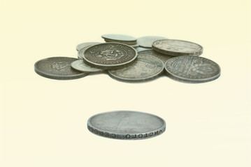 A bunch of old Russian coins of silver, of different denominations on a light yellow background
