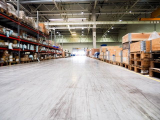 Warehouse industrial premises for storing materials and wood, there is a forklift for containers. Concept logistics, transport. Motion blur effect. Bright sunlight.