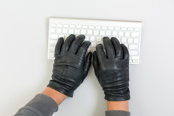 Hacker Hands breaking network protection on white keyboard