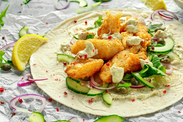 Fresh Fish Tortilla with cucumber, red onion, Capers, lemon, salad leaves and tartare sauce. Healthy Food