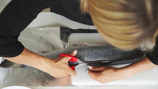 Woman cut salmon int steak