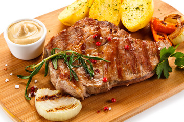 Steaks, baked potatoes and vegetable salad