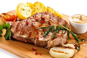 Steaks, baked potatoes and vegetable salad