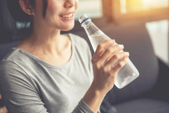 Happy woman drinking cold water in morning - Closeup