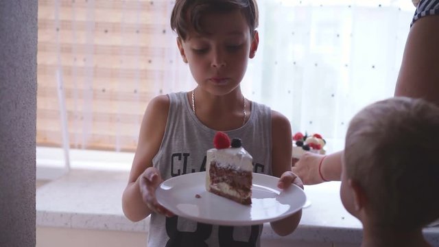 The woman puts the cake in the dish to children