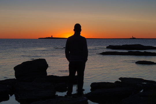 Silhouette human watching the sunrise. The island of Gotland in the Baltic sea.