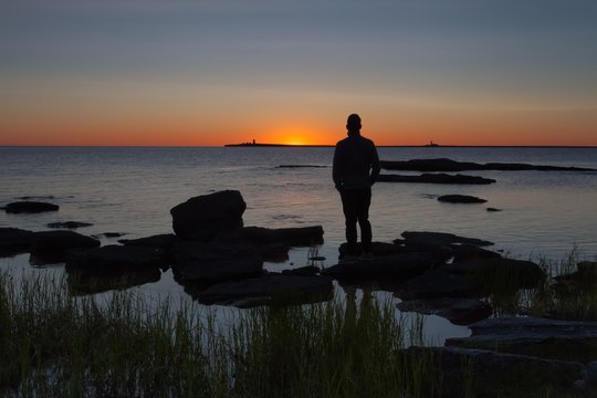 Silhouette human watching the sunrise. The island of Gotland in the Baltic sea.