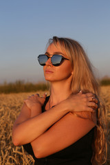 Молодая светловолосая девушка в солнцезащитных очках...