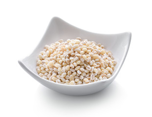 Heap of pearl barley in a bowl on white background