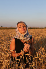 Молодая девушка с платком на пшеничном поле
