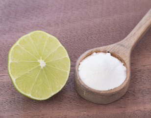 Lemon and baking soda on wooden table