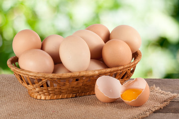 eggs in a wicker basket on a wooden board with blurred garden background