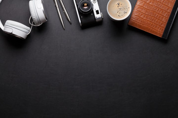 Office desk table with notepad, headphones, camera