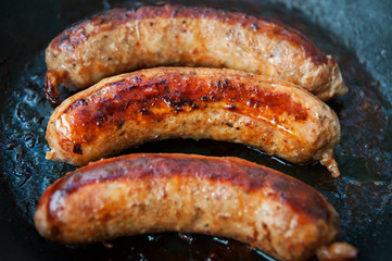 Home-made Pork Sausages in rustic pan with thyme. Bavarian sausages