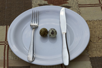 breakfast. two quail eggs in a white plate