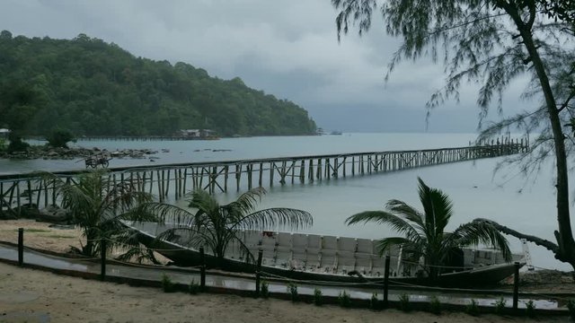 Wooden pier on the tropical beach on a rainy day