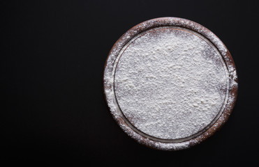 Fresh brown eggs in carton on black background