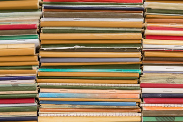 A stack of old school notebooks. Multicolored cover.