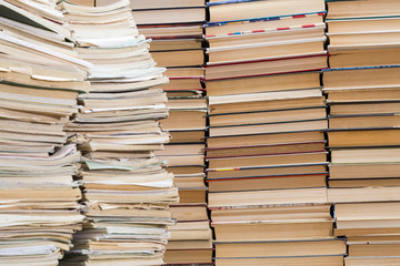 A stack of old school notebooks and a stack of textbooks or books.