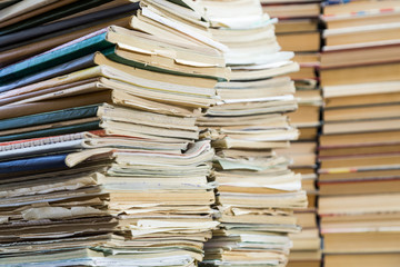 A stack of old school notebooks and a stack of textbooks or books.