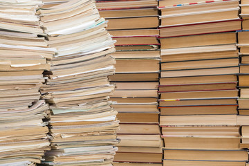 A stack of old school notebooks and a stack of textbooks or books.