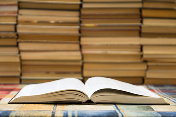 A stack of books with colorful covers. The library or bookstore. Books or textbooks. Education and reading. Open book in the foreground.