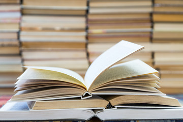 A stack of books with colorful covers. The library or bookstore. Books or textbooks. Education and reading. Open book in the foreground.