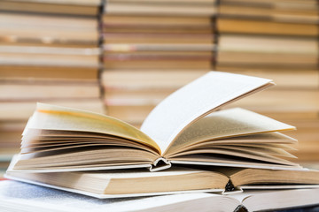 A stack of books with colorful covers. The library or bookstore. Books or textbooks. Education and reading. Open book in the foreground.
