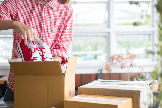 Business Owner Packing Shoes In The Box At Workplace. Freelance Woman Seller Prepare Product For Packaging Process At Home.  Online Selling, Internet Marketing, E-commerce Concept