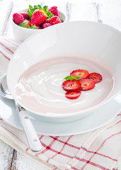Fresh strawberry yoghurt in a bowl with fresh berries